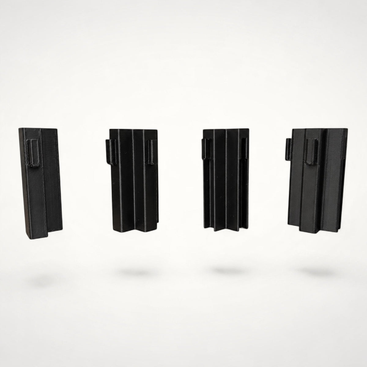 Four black NG Organisers corner wall modules for drawer divider systems shown from different angles.